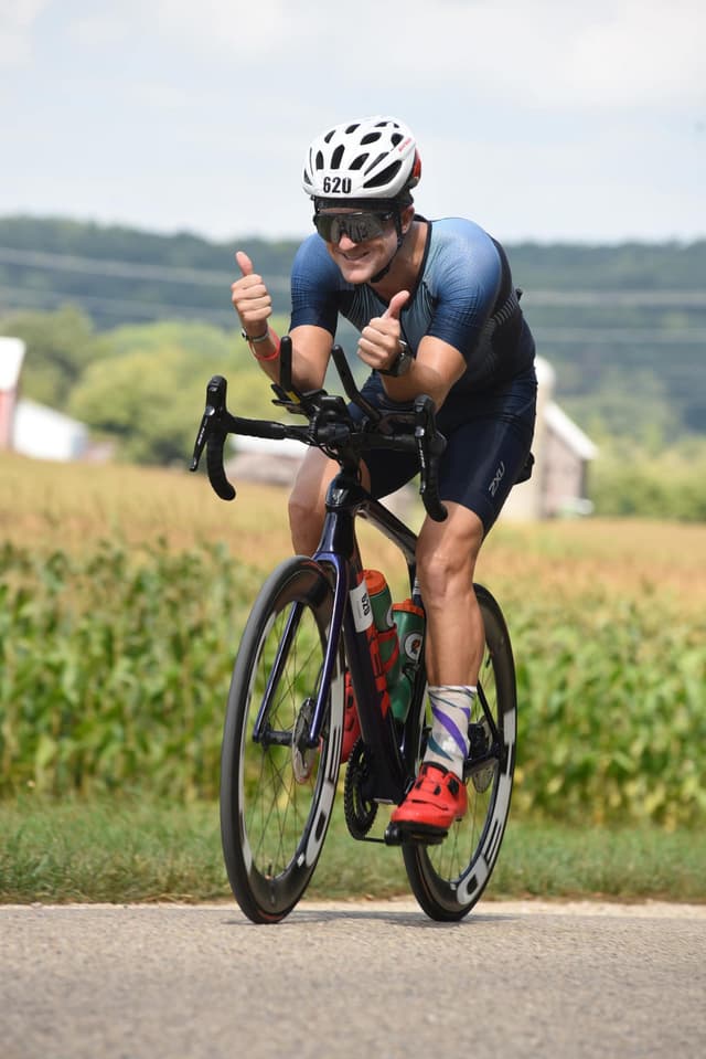 Sam giving the camera man a thumbs up while biking the Madison Iron Man